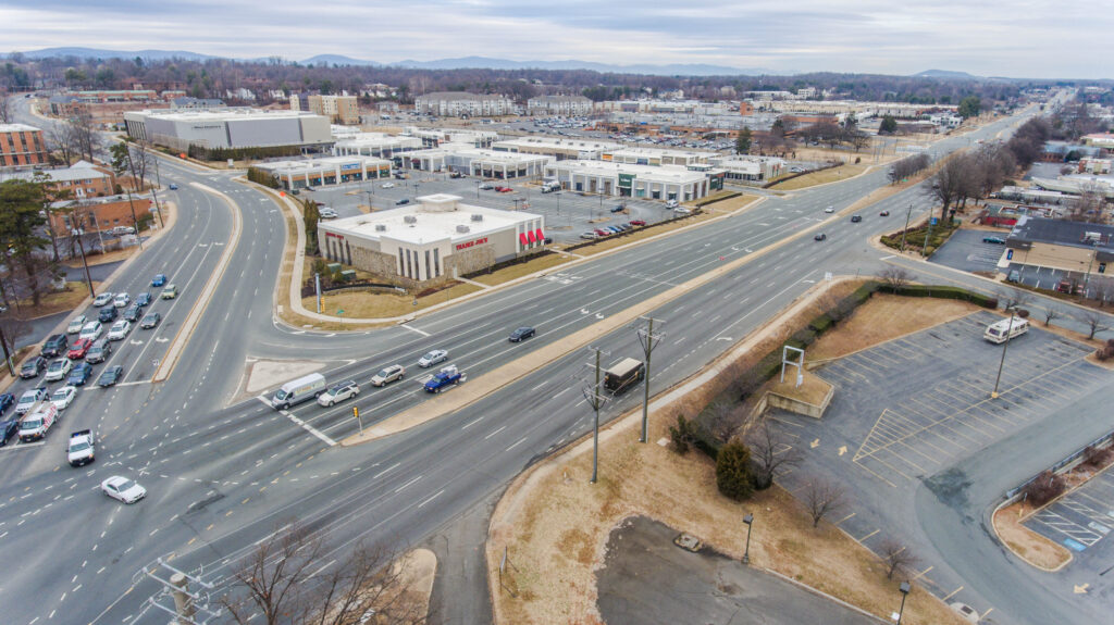 Photo of intersection with retail buildings and parking lots