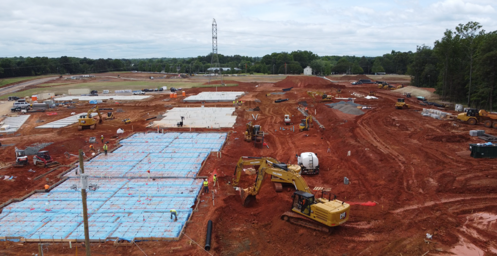 Construction site with excavator and concrete pads